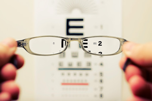 holding glasses in front of eye test
