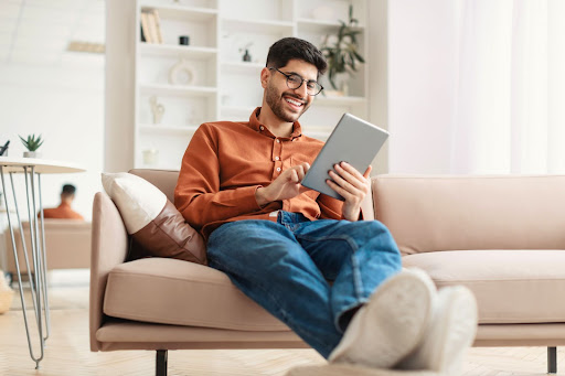 man sitting on a couch with a tablet