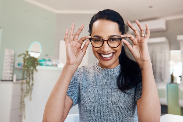 smiling woman trying on glasses